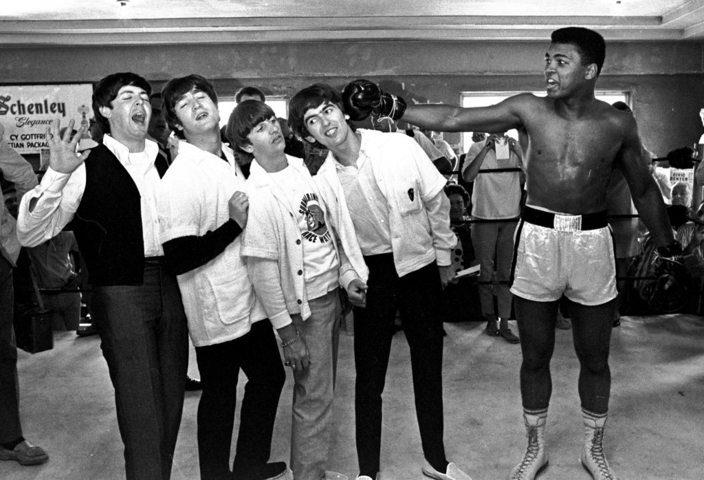 FILE - In this Feb. 18, 1964, file photo, The Beatles, from left, Paul McCartney, John Lennon, Ringo Starr, and George Harrison, take a fake blow from Cassius Clay, who later changed his name to Muhammad Ali,  while visiting the heavyweight contender at his training camp in Miami Beach, Fla. Ali turns 70 on Jan. 17, 2012. (AP Photo/File)